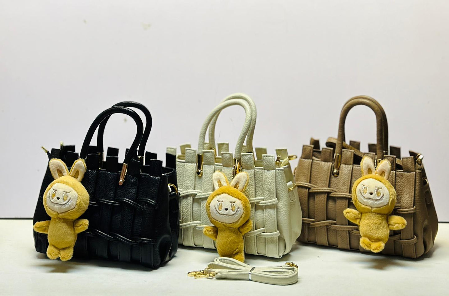 Three handbags in black, beige, and brown